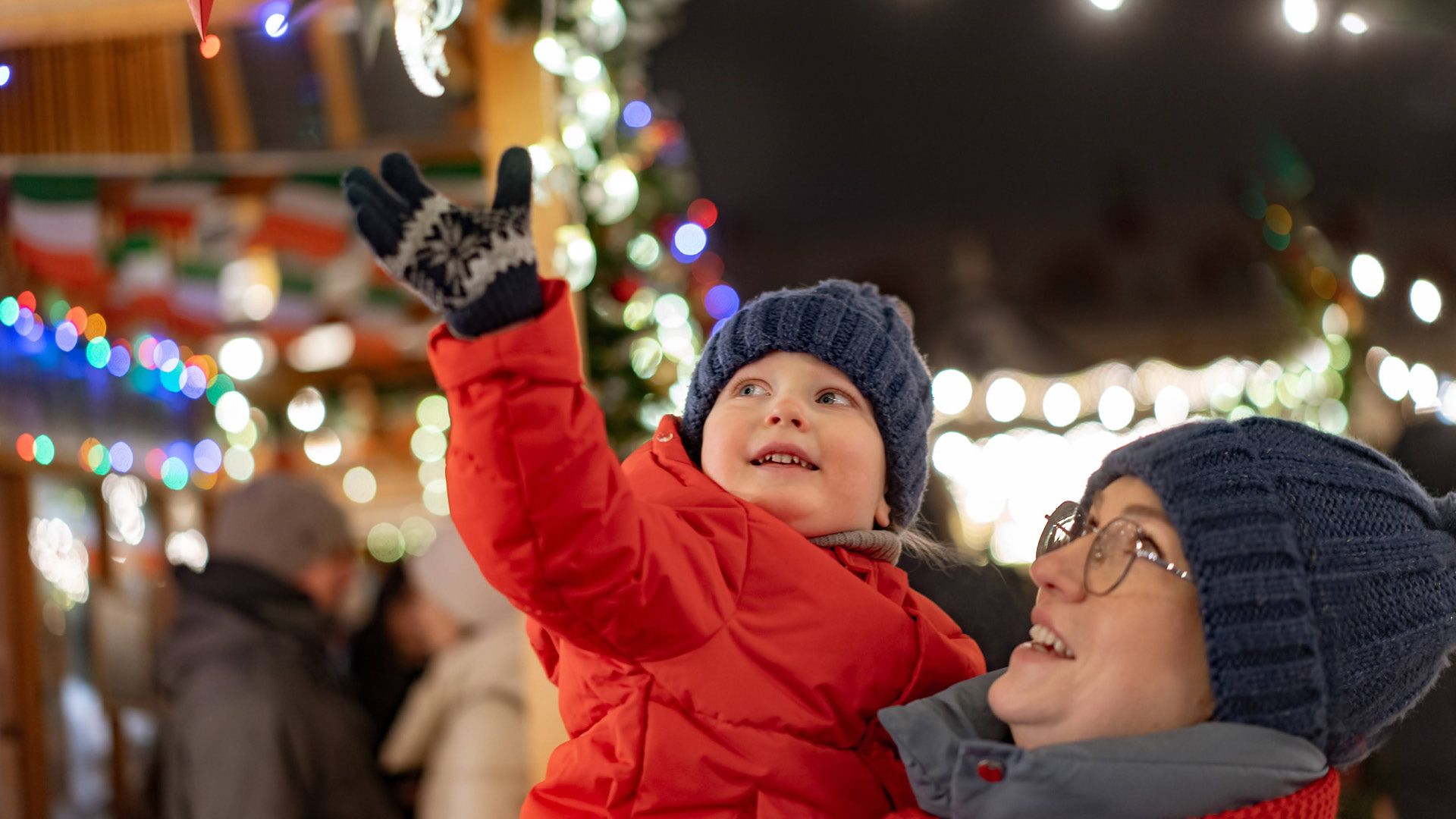 child reaching up to grab an ornament