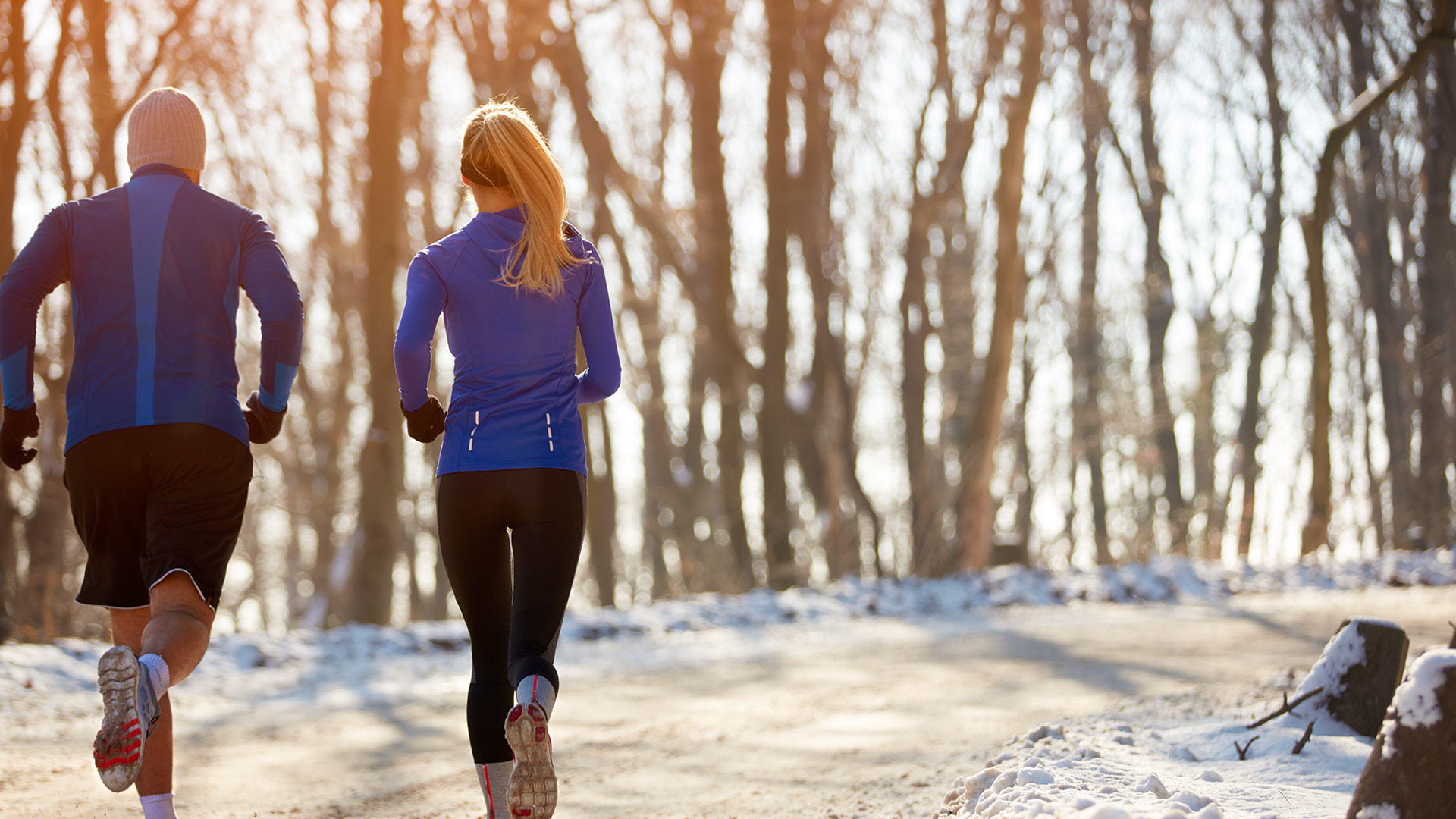 two people running on a winter trail